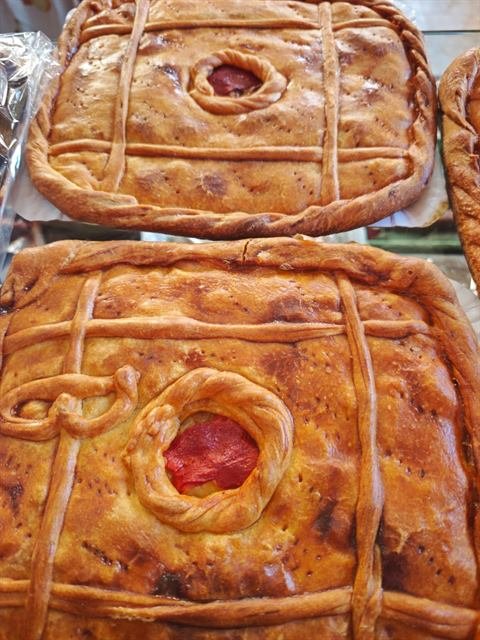 Empanadas gallegas recién hechas, con pimiento asomando por el centro